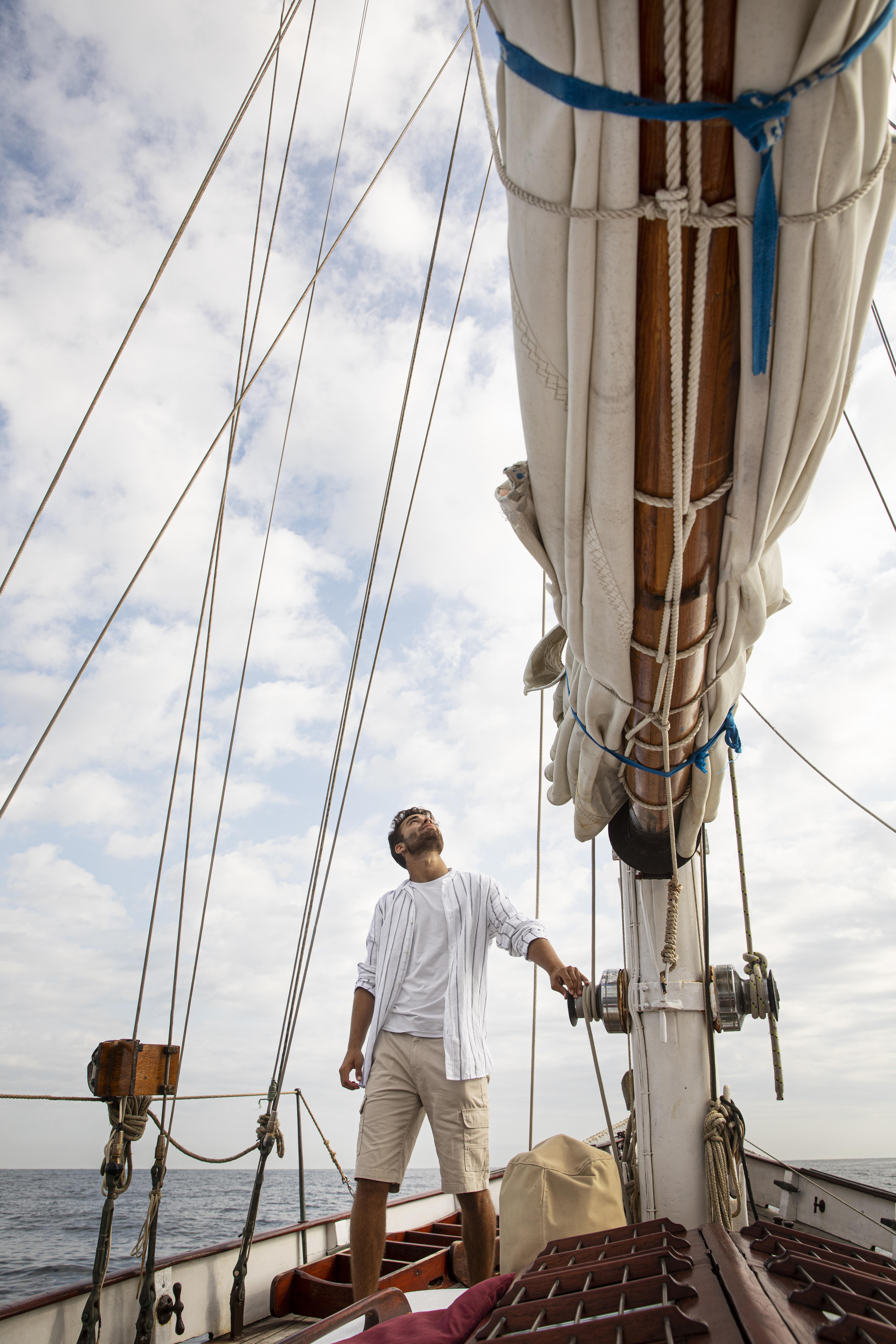 Home que està denpeus sobre el bauprès i mira cap la punta del màstil de la major. Es poden apreciar la exarxia.